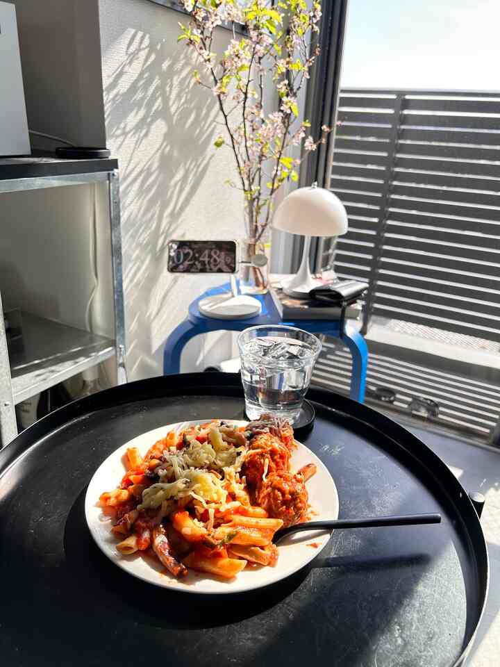 Charcoal and blue toned 6-tatami room with window-side seating, compact table, and portable lamp in a simple home cafe space