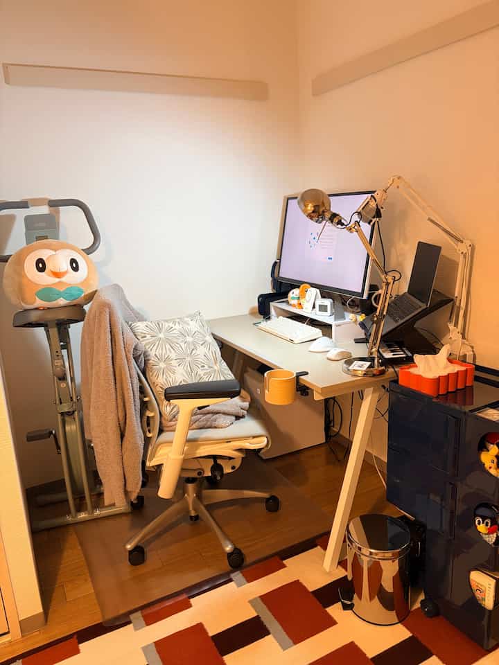 暖かいベージュとホワイトのトーンのホームオフィス、机とコンピューター、オフィスチェアが配置された居心地の良い作業空間