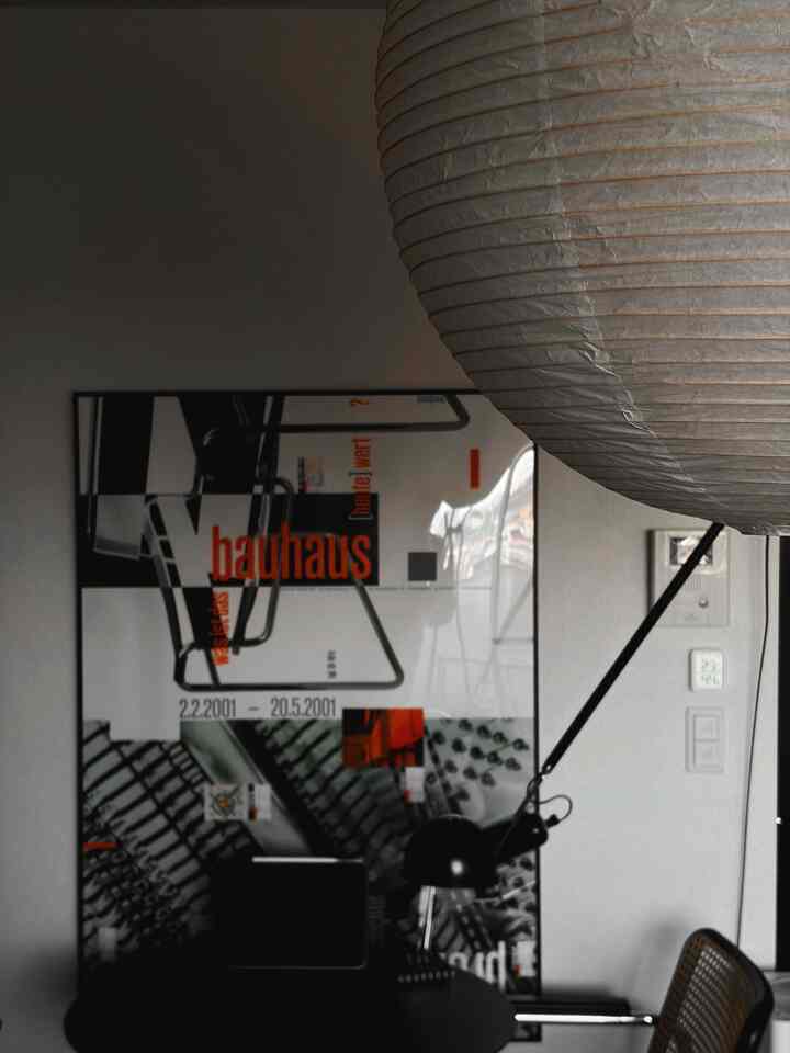 ホワイトとブラックのトーンでまとめられたミニマルなホームオフィス空間、ペンダントライトとブラケットライトが印象的なインテリア