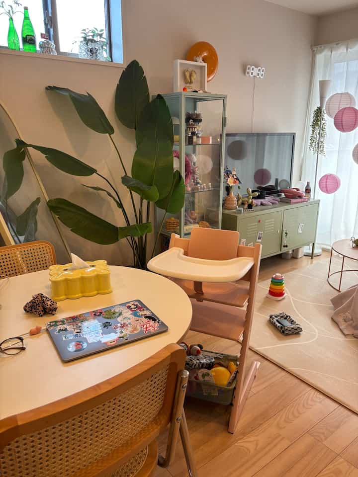 Natural color and white-toned dining room featuring a baby high chair and toys, creating a warm atmosphere