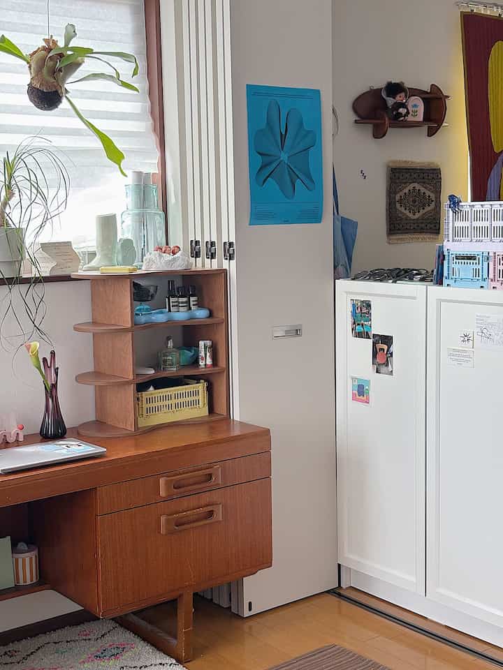 白とブラウンの色調のリビング、木製の机と棚が配置された印象的で自然なインテリア