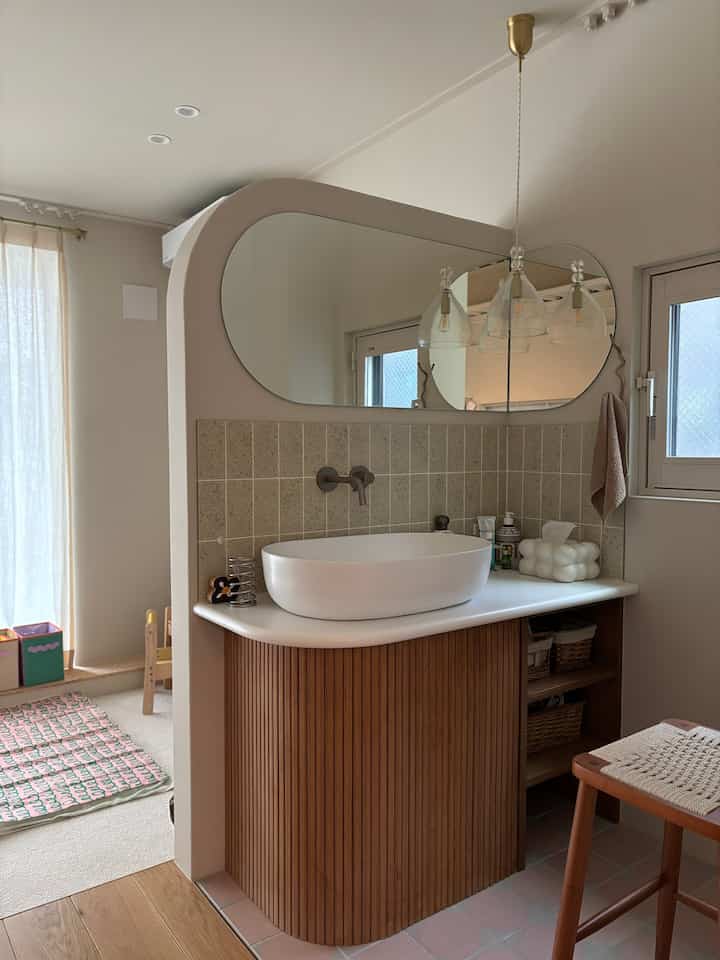 White and brown toned bathroom featuring a washbasin and large mirror with a natural and cozy atmosphere