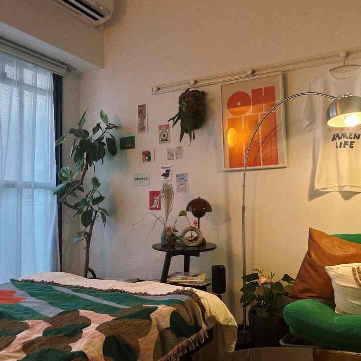 ホワイトトーンの寝室、ミッドセンチュリーモダンスタイルの家具と植物が配置された落ち着いた雰囲気のインテリア