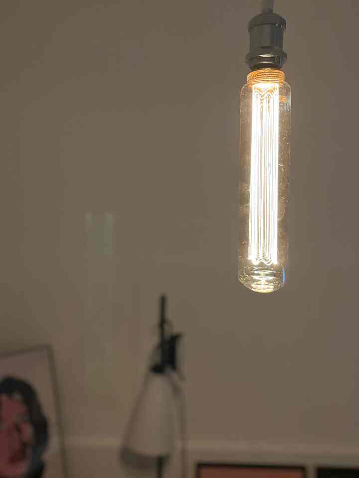 暖かいゴールド色のペンダントライト電球が暗い空間で輝いている雰囲気のあるインテリア