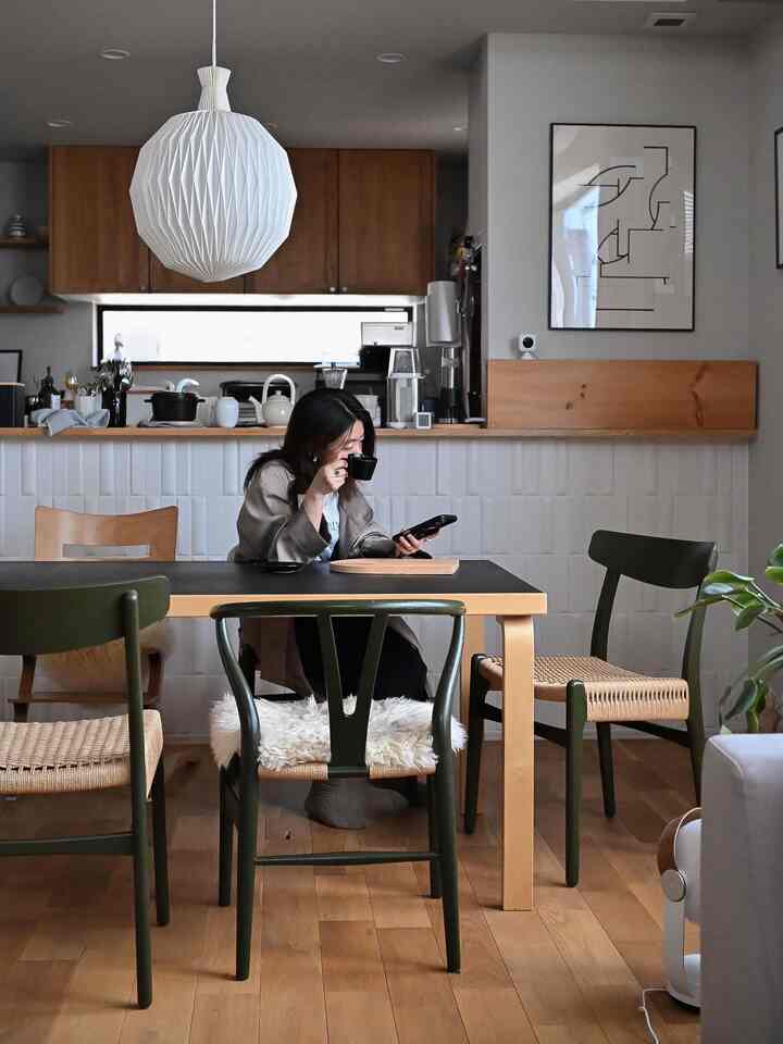 ナチュラルな木目調と白いペンダントライトが調和するキッチンとダイニング、シンプルで落ち着いた雰囲気のインテリア