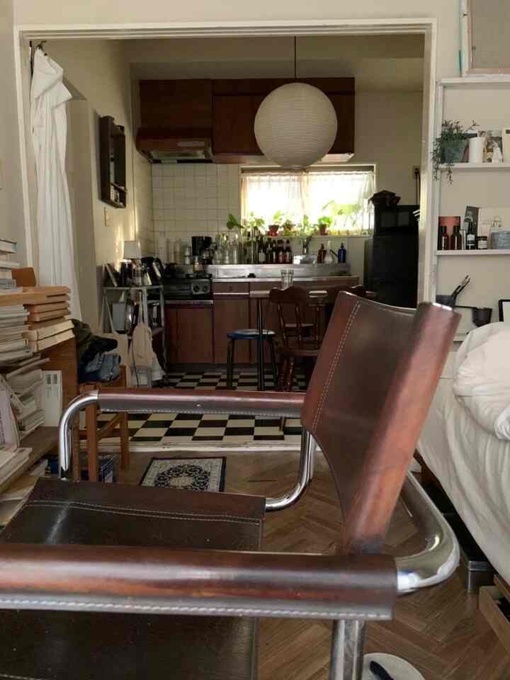 Brown furniture and natural tones in an apartment dining room featuring mugs and a vintage-style chair, creating a warm atmosphere