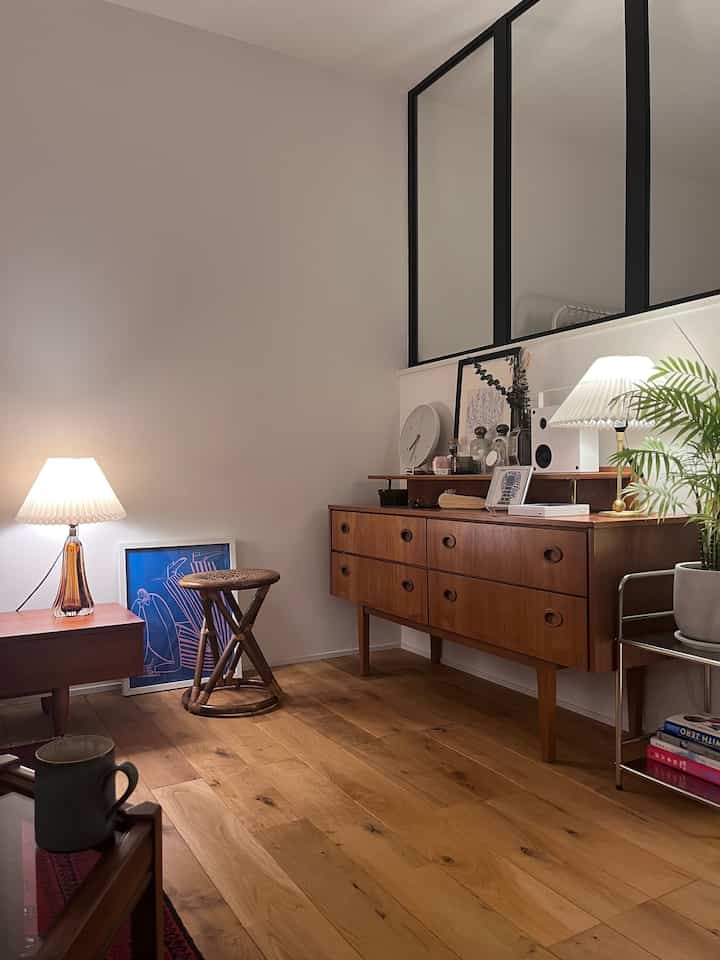 Wood tone dining room featuring vintage mid-century modern sideboard and table lamps with cozy atmosphere