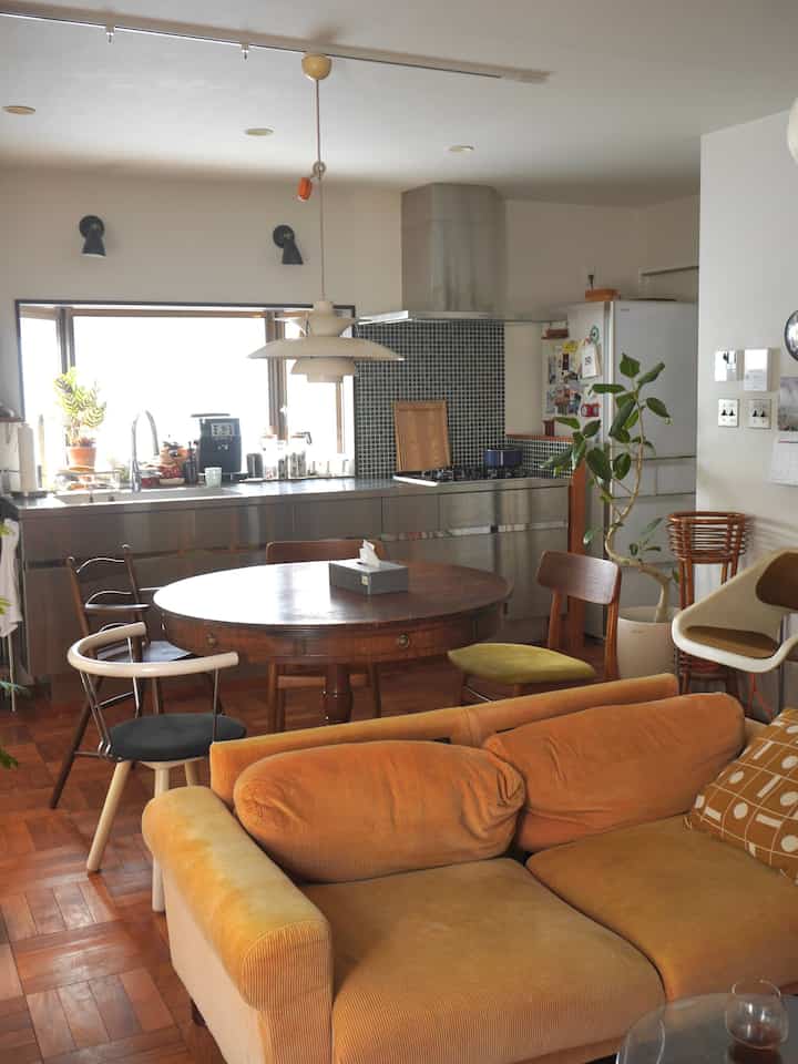 Cozy living and kitchen space in warm brown and natural tones, featuring wooden dining table and stainless steel countertop harmony