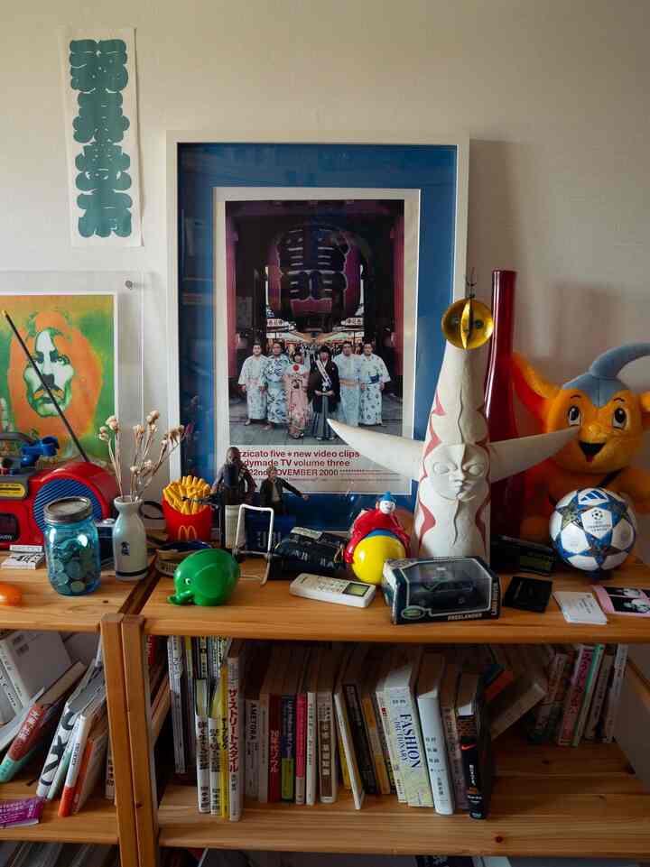 Natural wood-toned shelves featuring various posters and toys arranged in a cozy and eclectic space