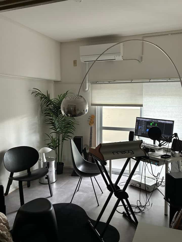 Monotone studio home office featuring an Arco floor lamp and black furniture in a modern interior