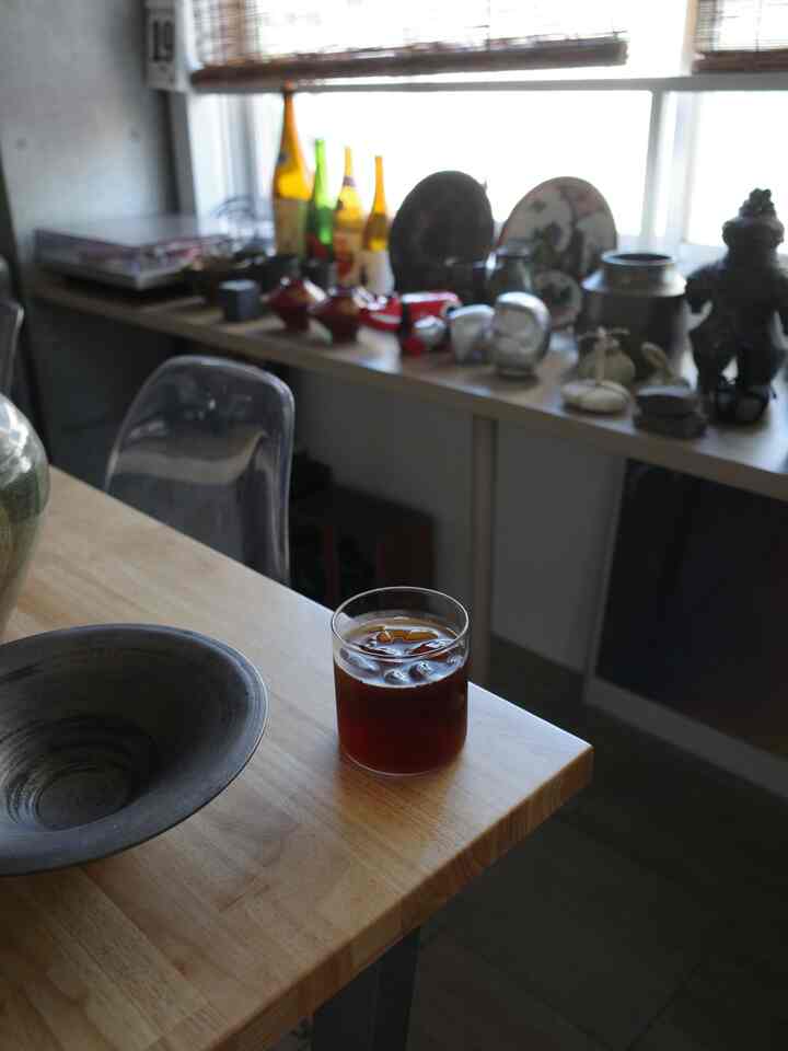 Natural wood-tone table near a window features iced coffee in a cozy cafe-style setting