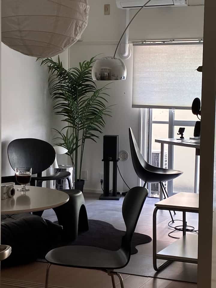 Monotone single household space featuring Fritz Hansen chairs and pendant lighting with a modern, clean interior
