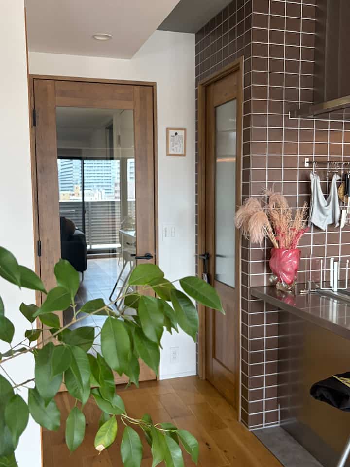 Natural wood tones and brown tiled pantry kitchen with glimpse of living room in a modern natural interior