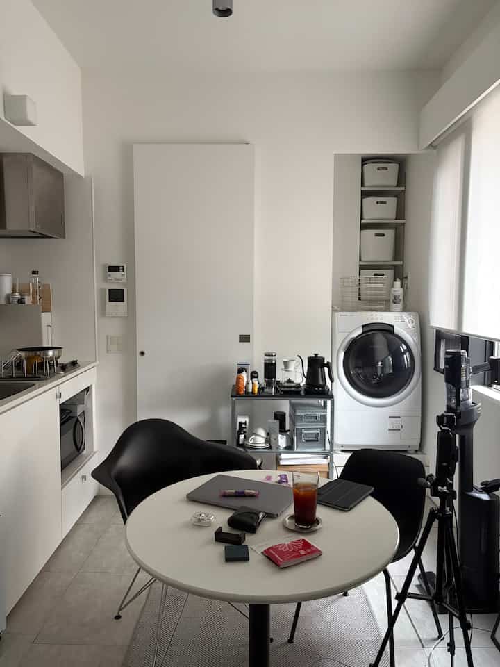 White and black toned kitchen and dining room featuring a side table with coffee equipment in a modern and compact space