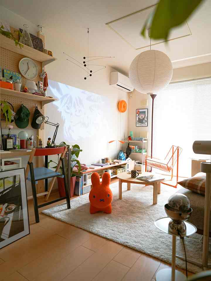 Natural tone living room with orange accents, featuring a wooden coffee table and desk creating a warm atmosphere