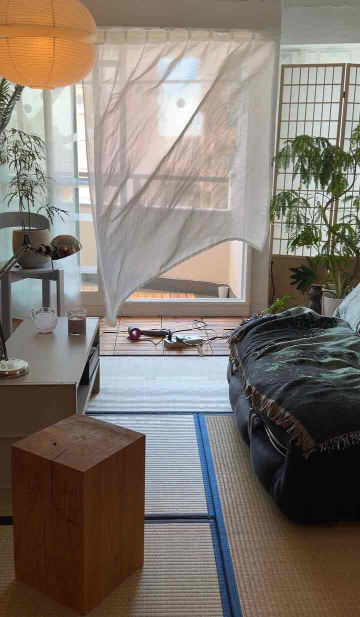 白いカーテンと畳が印象的なジャパンディスタイルのリビング、木目調家具と自然光が調和した雰囲気のあるインテリア