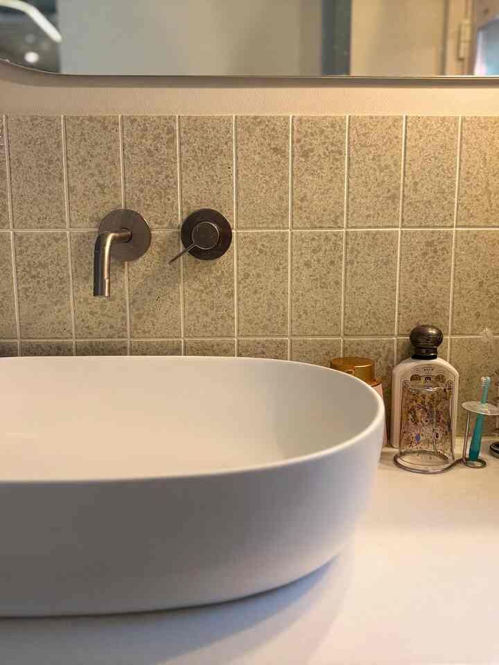 Bathroom space with beige tone tiled wall and white wash basin