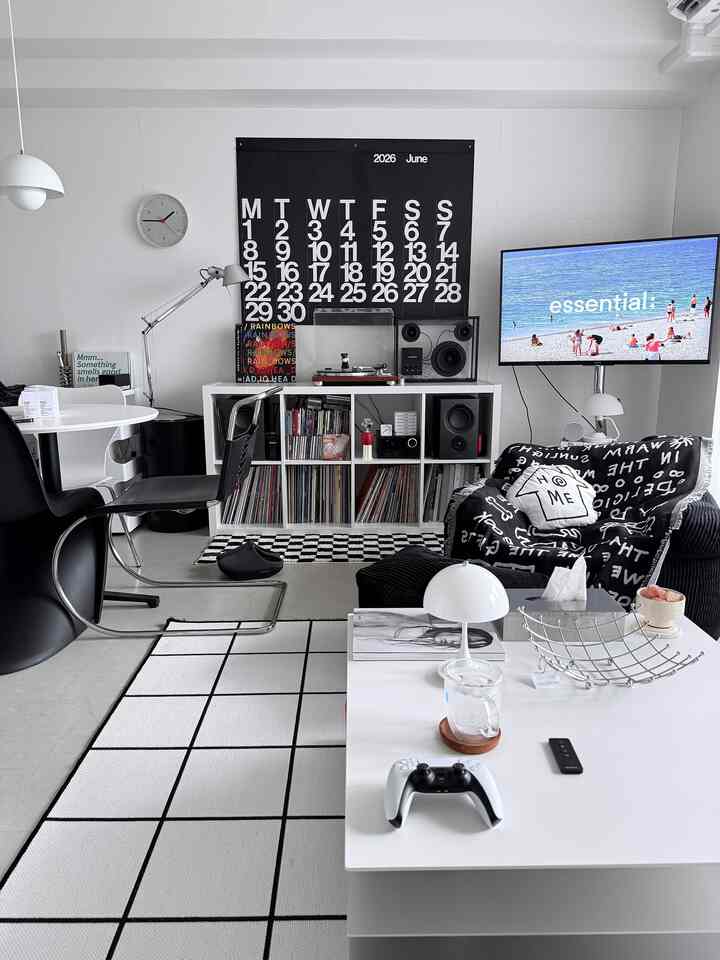 Monotone and white-toned living room featuring black sofa and white coffee table, creating a simple modern atmosphere