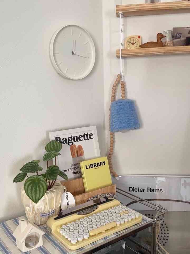 Natural color home office space featuring a yellow vintage typewriter and green plant with a cozy atmosphere