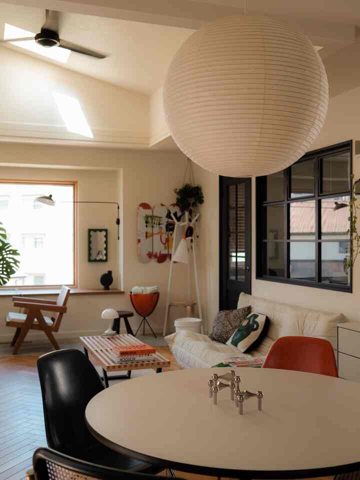 White and wood tone Mid-Century Modern living room featuring pendant light and cozy furniture arrangement