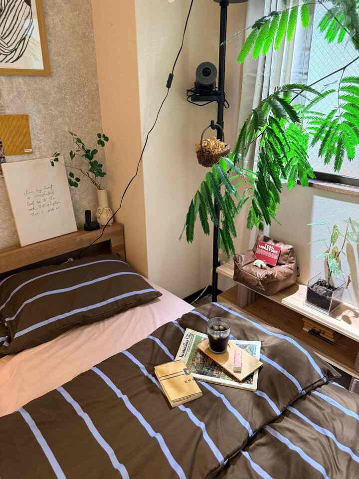 ベージュとブラウンのナチュラルカラーの寝室、植物が配置された落ち着いた雰囲気のあるインテリア