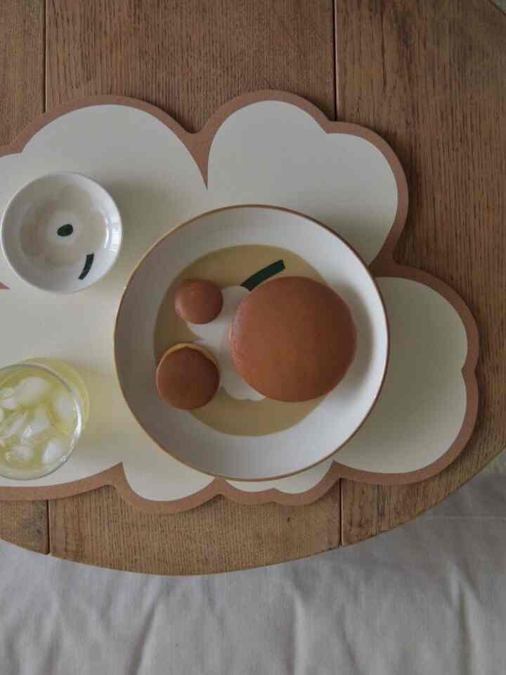 Natural brown-toned kitchen table featuring tempered glass product, desserts, and tea, creating a cozy home cafe atmosphere