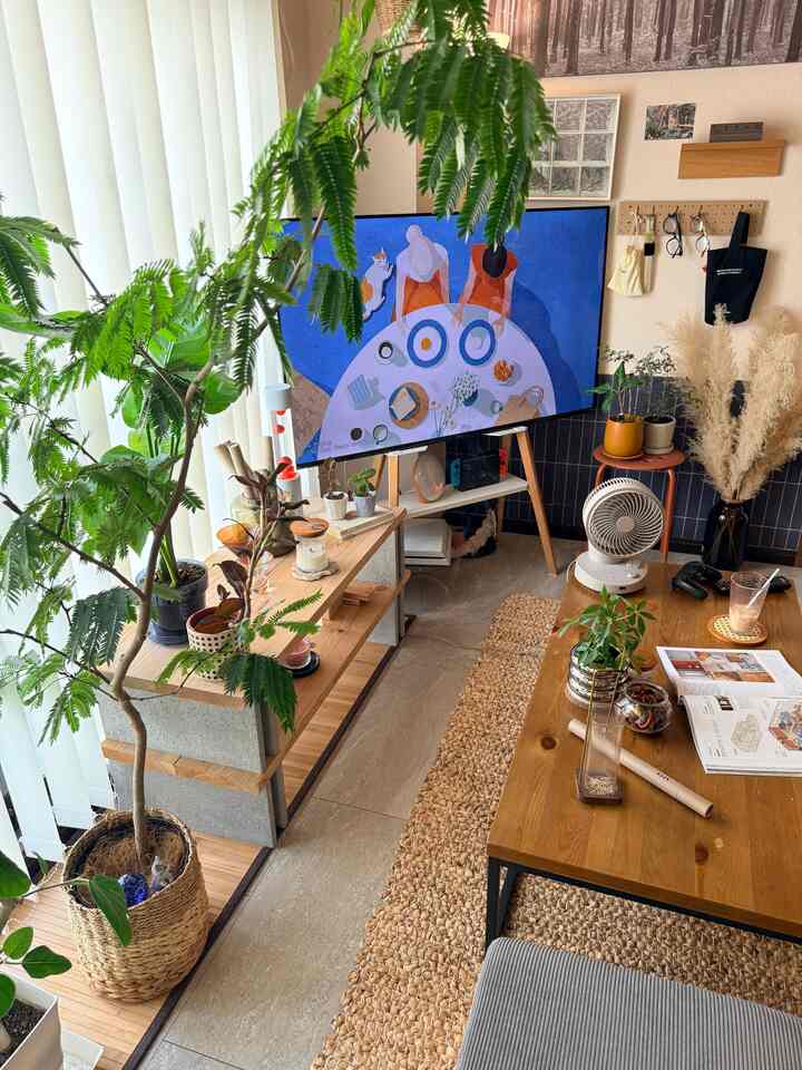 ナチュラルな木目調のリビング、豊富な植物が配置された雰囲気のあるホームカフェスペース