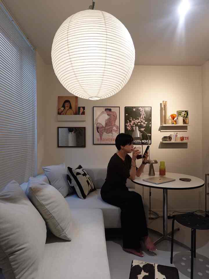 White-toned small living room featuring a simple sofa and round coffee table with a modern and cozy atmosphere