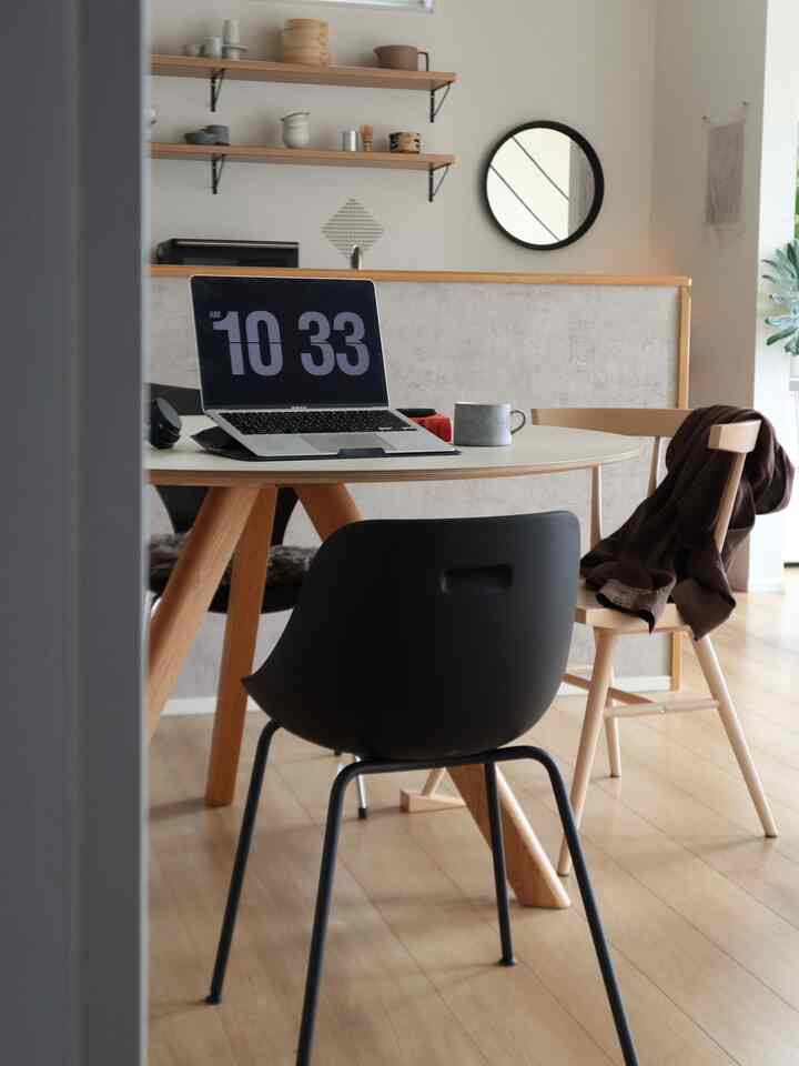 White and wood tone dining room featuring simple modern home office setup with desk and chairs.