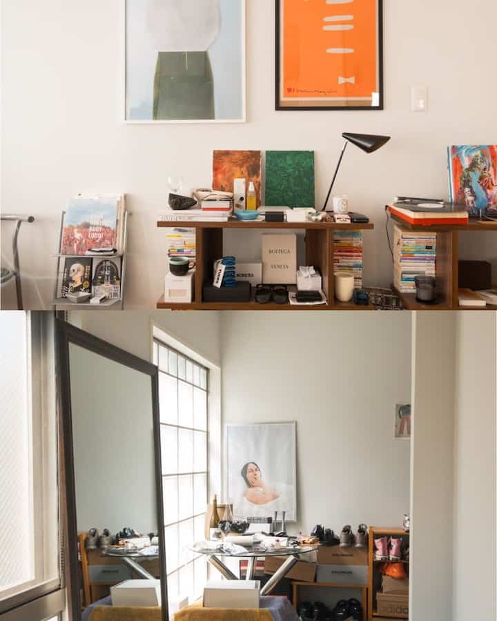 White-walled studio apartment dining area with wood tone furniture, bookshelves, and a large mirror creating a cozy atmosphere