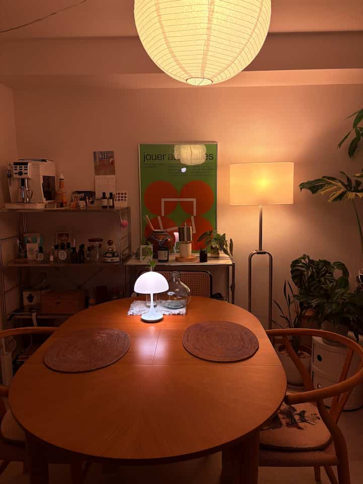 Warm beige tone dining room featuring a wooden dining table and various lighting creating cozy atmosphere