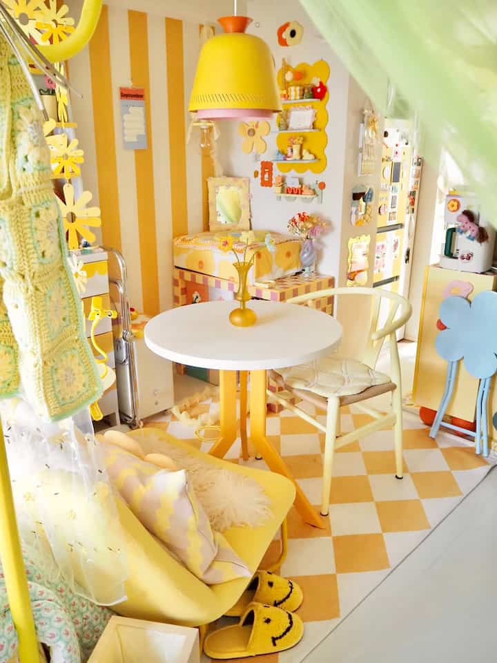 Bright yellow-dominant compact space featuring round table and yellow pendant light in a cozy kid's room style