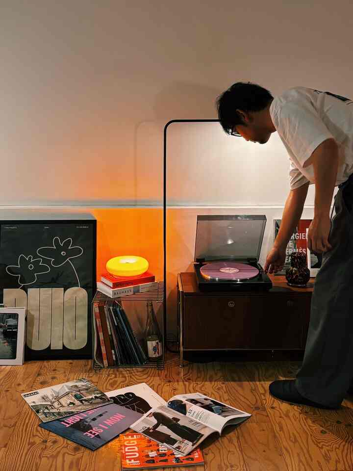 Warm orange-lit Mid-Century Modern music listening space featuring wood-tone furniture with a cozy atmosphere