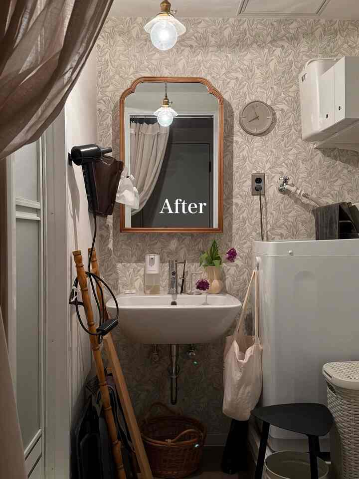 White and brown wood tone compact bathroom featuring a wash basin, pendant light, and large mirror with functional layout
