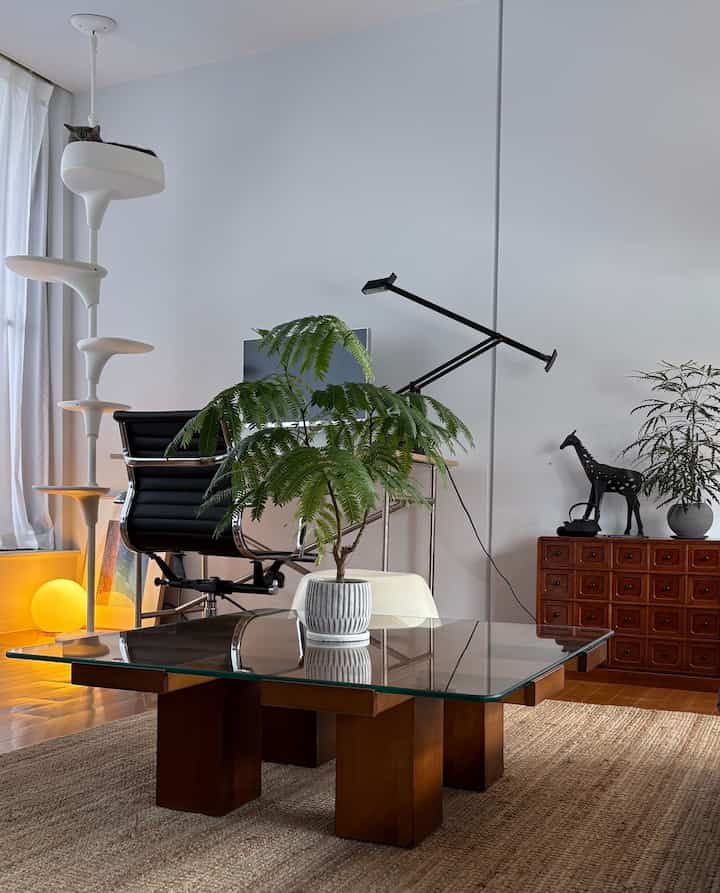 White and brown toned living room featuring desk, cat tower, and plants with a modern natural atmosphere