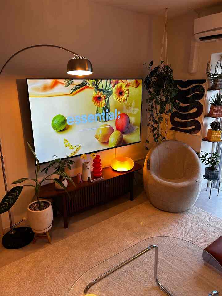 Beige wood-toned living room featuring a massage chair and plants with a cozy atmosphere