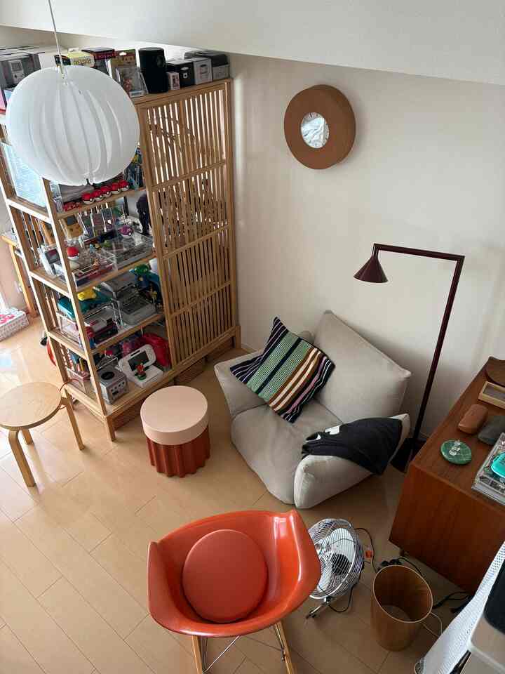 Compact living room with natural wood tones, beige sofa, and orange armchair