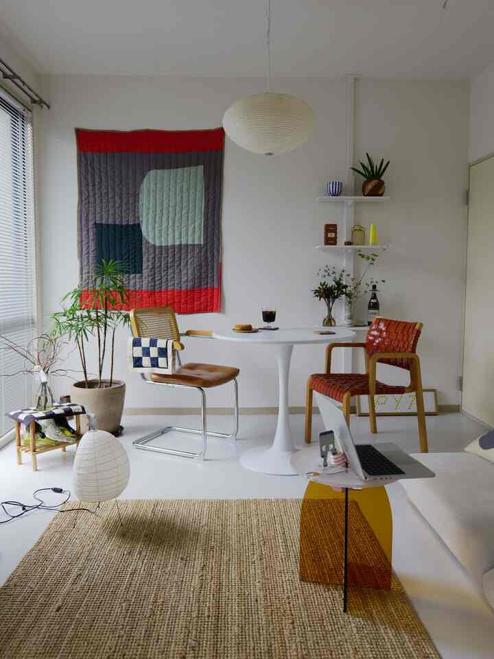Natural toned dining room featuring a white round table and wooden chairs in a cozy Nordic style space