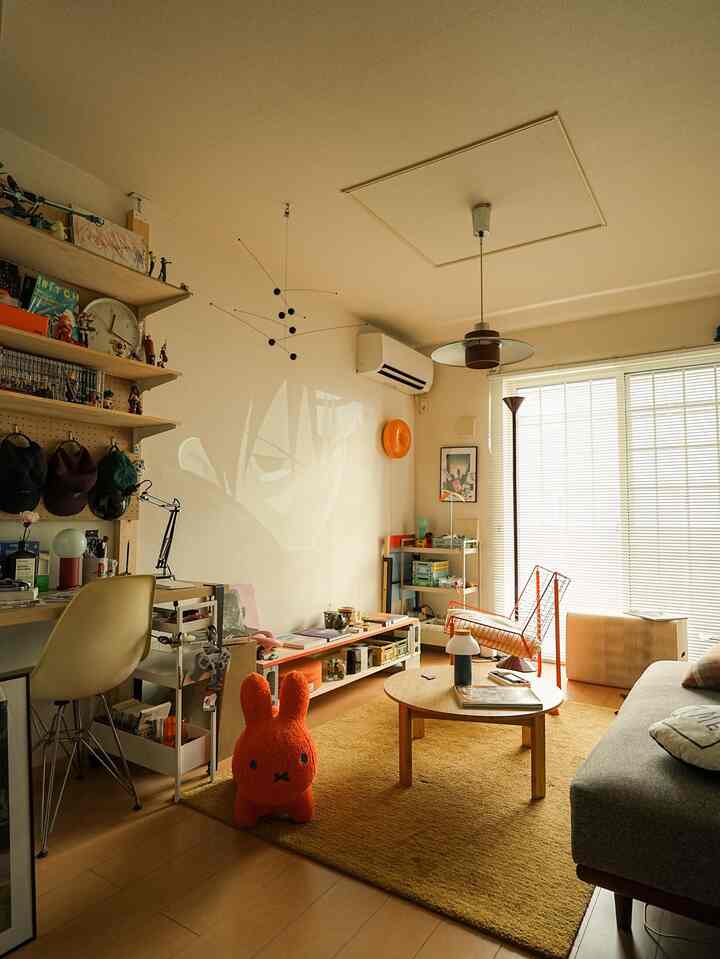 Beige and orange toned living room featuring sofa, coffee table, and a projector image on the wall creating a cozy atmosphere