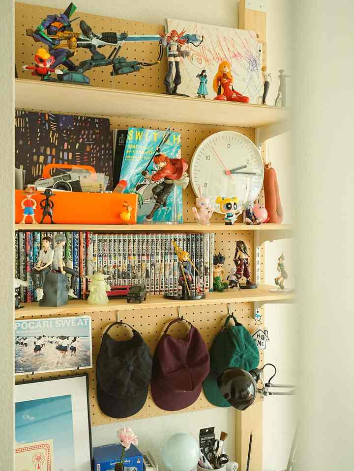 Natural tone living space featuring figurines and manga books displayed in a distinctive hobby zone