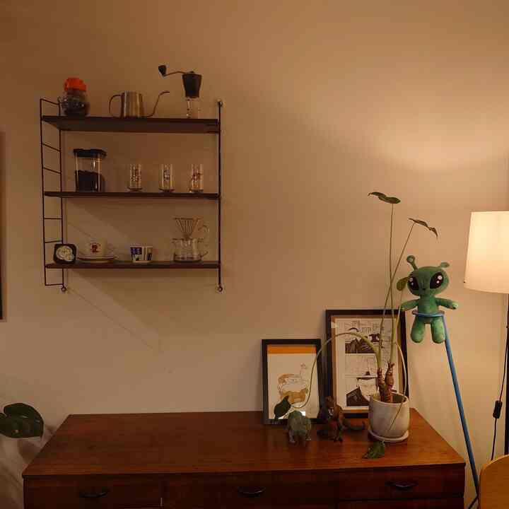 Warm beige-toned wall and wood tone sideboard featuring coffee set and natural cafe-style interior