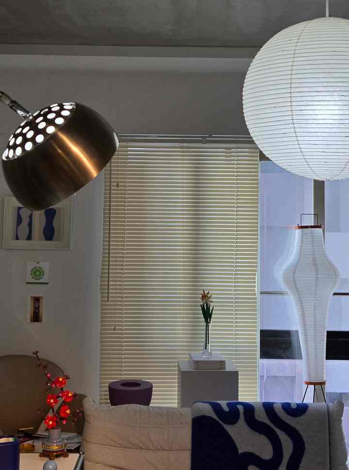 アイボリーとベージュのトーンの1LDKリビング、ノルディックスタイルのソファとイサムノグチのアカリペンダントライトが配置された雰囲気のある空間