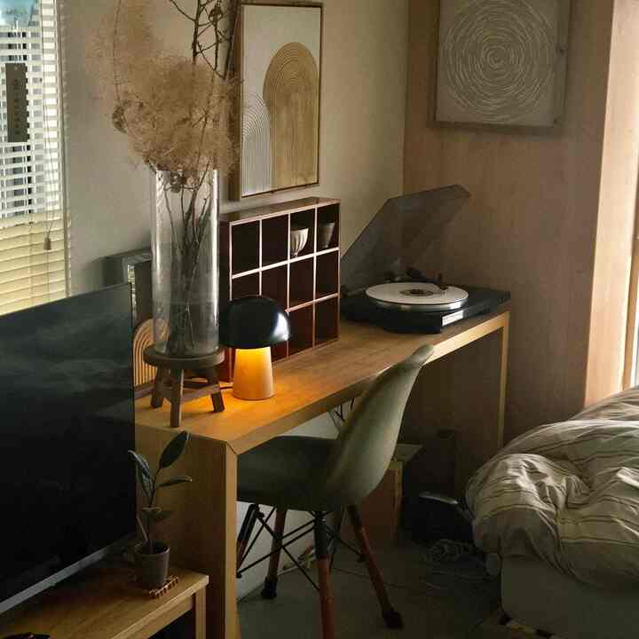 Cozy bedroom home office with natural wood tones and soft ambiance, featuring a desk and office chair in a warm interior