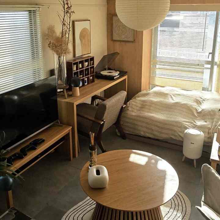 Natural-toned bedroom featuring wood furniture and bright blinds allowing natural light in, showcasing a Nordic interior style