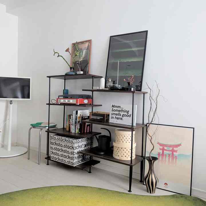 White-walled and floored living room with green rug and natural material furniture in a natural style