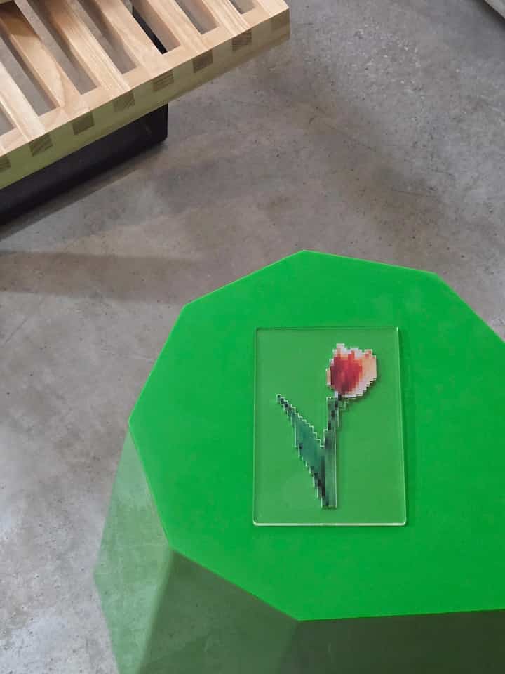 グリーンのアーノルドサーカススツールと木製ベンチが配置されたナチュラルモダンな1LDKの空間