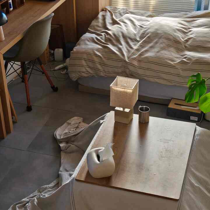 温かみのある木目調とベージュの寝室、シンプルなデスクと椅子が配置された自然な雰囲気のある空間