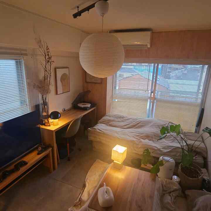 Warm wood tone natural modern bedroom featuring pendant light and desk, creating a cozy single household space