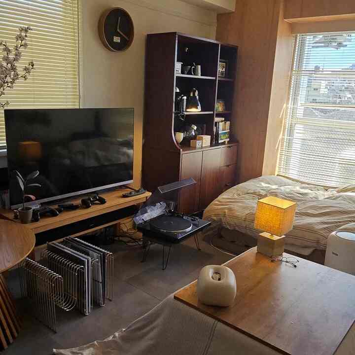 Warm wood tones and beige bedding define a single household bedroom and game room space