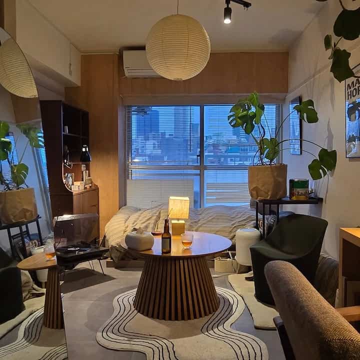 Natural wood tone and beige single household bedroom featuring round coffee table and pendant light in a cozy space